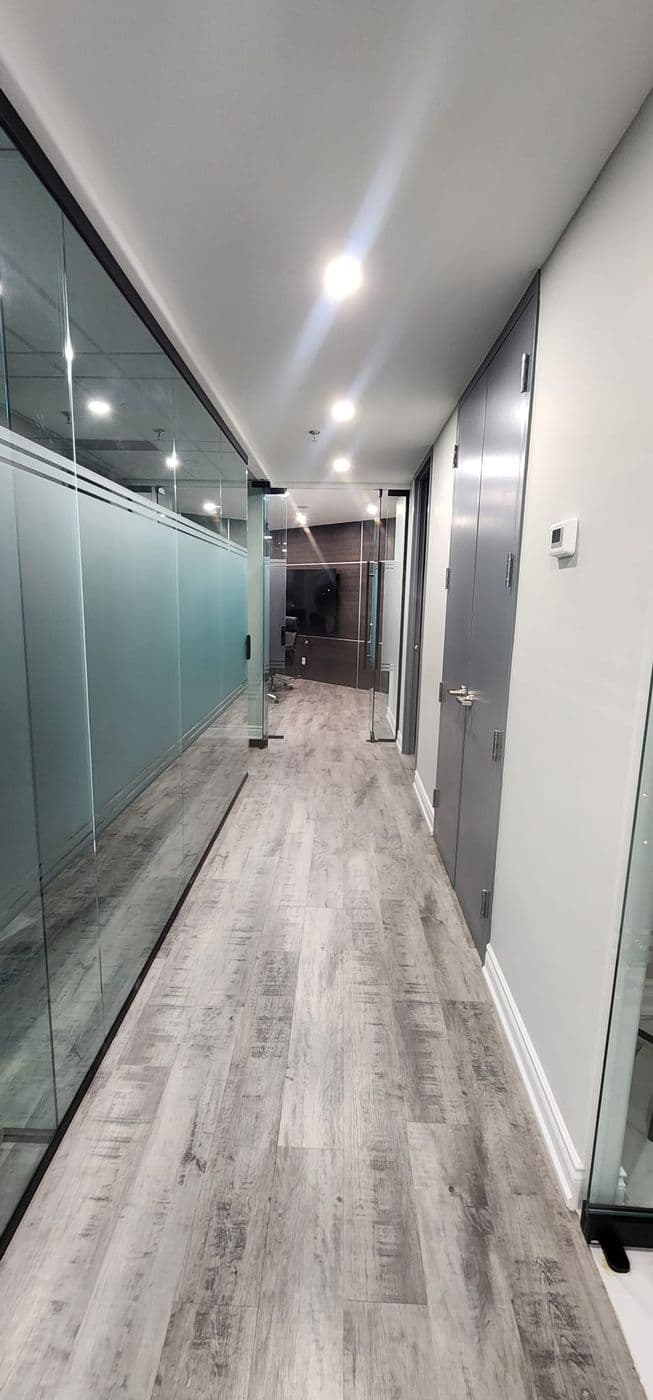 A glass-walled corridor running between the firm's offices toward the boardroom.
